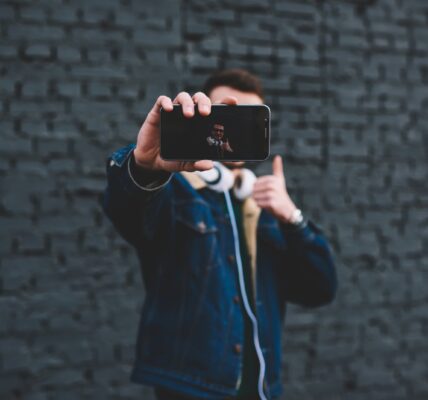 Jak skutecznie wykorzystać marketing influencerów w małych firmach 6 young-man-showing-smartphone-display-beside-brick-2023-11-27-05-02-38-utc